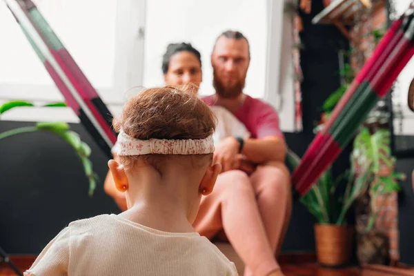 Anne ve baba kucaklaşıp kızlarını evde izliyorlar.