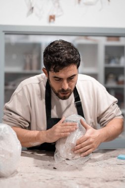 Dükkan sahibi bir el sanatları dükkanında hediye paketi yapıyor..