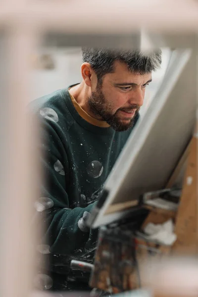 Gülümseyen ve tuvali boyayan bir adamın orijinal portresi. Sanat ve sanatçı konsepti.