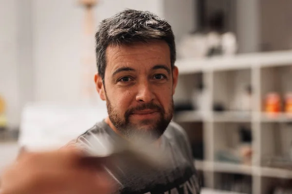 Resim stüdyosundaki tuvale resim yapan erkek ressamı kapat. Bir resim stüdyosunda yaratıcılık ve ilham. Tuvalin bakış açısı. ilk kişi görünümü