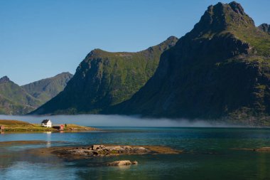 Lofoten adalarında güzel bir manzara, fiyortta küçük bir ev, sisli bir hava..