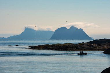 Norveç 'teki deniz manzarası, sisli yaz gökyüzü. Önplanda tekne.