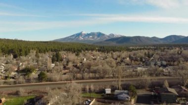 Flagstaff 'ın ilkbaharda hava görüntüsü, 4k, 30 fps, gündüz, karla kaplı dağlar, şehir manzarası