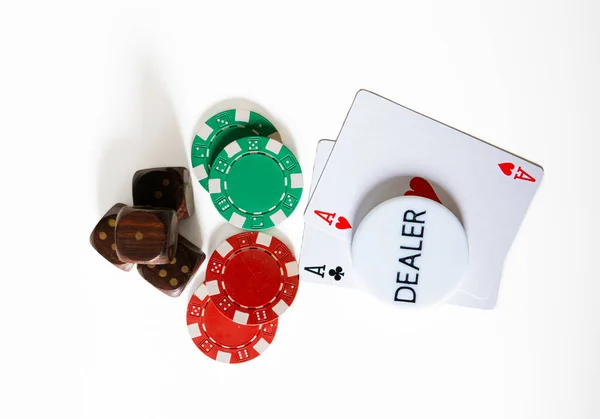 Bir çift poker kartı, iki as, poker fişi, zarlar ve bir dağıtıcı düğmesi.