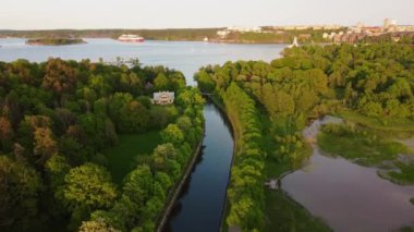 Stockholm, İsveç yakınlarındaki bir kanaldan harika bir akşam uçuşu manzarası. Akşam ışığı, hava manzarası, yemyeşil bitki örtüsü. 4K çözünürlük, 30fps.