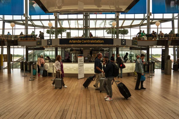 Stockholm-Arlanda, İsveç - 29 Ağustos 2023 İsveç havaalanına varış bölgesi tren istasyonunun girişi ve farklı yönlerde yürüyen insanlar