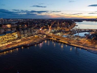 Stockholm ve Slussen 'in hava manzarası alacakaranlıkta, şehrin ışıkları denize yansıyor..