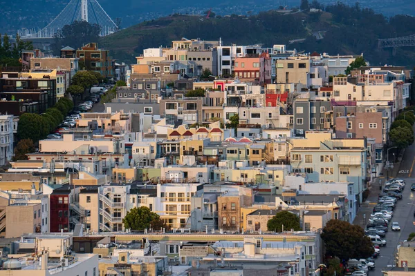 San Francisco 'nun renkli evleri ABD' nin baharda yağan fırtınadan sonra tepenin zirvesine tırmanıyor. Arkaplanda kara bulutlar.