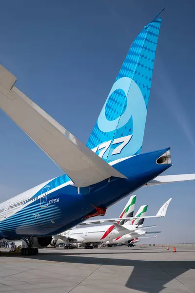 Dubai, Birleşik Arap Emirlikleri, 16 Kasım 2023. Dubai Hava Gösterisi. Hava gösterisinde sergilenen bir Boeing 777 'nin kuyruğu ve arka planda birkaç Emirates Havayolları uçağı..