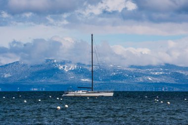 Tahoe Gölü, ABD - 3 Mayıs 2023: Geç bahar kar fırtınasından sonra Tahoe Gölü 'ne demir atmış bir yelkenli..