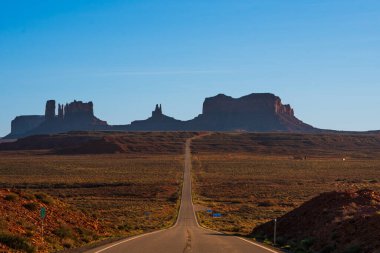 Günbatımında Utah 'ta Forrest Gump bakış açısıyla ünlü bir anıt vadisi manzarası. Ufukta büyük popolar ve kayganlaştırıcılar var.