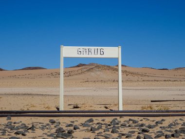 Eski istasyon işareti Garub, Namibya ve Güney Afrika 'daki Luderitz arasında terk edilmiş bir istasyon, ıssız çöl manzarası ve açık mavi gökyüzü..
