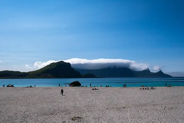 stock image The beach of Hauklandstranda in Lofoten, northern Norway, with people suntanning and bathing, turquoise sea, white sand, bright sunlight, summer.