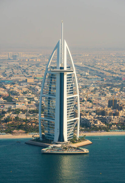 Dubai, United Arab Emirates -November 24th 2023: The luxury hotel Burj Al Arab seen from the sea with its pool, distinct shape and background of private luxury villas.