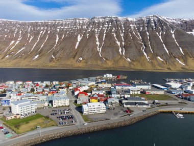 Isafjordur 'un havadan görünüşü, liman, İzlanda, renkli binalar, deniz, fiyort, karlı dağlar. Kutup iklimi, parlak ışık. Kutup iklimi. Westfjords bölgesi.