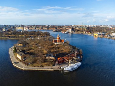 Stockholm, island of Kastellholmen, Kastellet fortification. Aerial view. Sailboat in the foreground. Stockholm city skyline. Early spring, blue sky. clipart