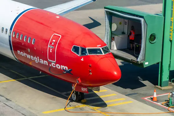 stock image Landvetter Airport, Sweden - May 21st 2024: A boeing 737-800 from Norwegian airlines, in typical red and white livery, about to dock at a gate. Bright sunshine, vivid colors