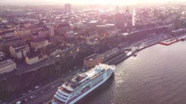Stockholm, Sdermalm bölgesinin hava manzarası ilkbahar yağmurundan sonra, sarı güneş ışığı, çatıda yansımalar, sarı ve turuncu renkler.