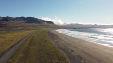 İzlanda 'nın manzaralı yolları, Snaefellsjokull stratovolcano' lu 54. yol, deniz, sahil, yeşil tarlalar ve karla kaplı dağlar. Parlak ışık, yazın başında. Yolculuk, özgürlük yollarda