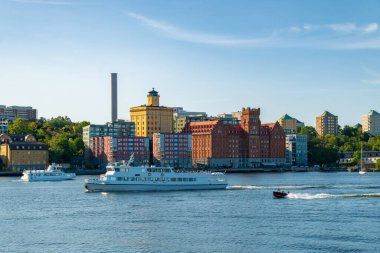 Stockholm, İsveç. Saltsjoqvarn 'ın eski sanayi bölgesi yenilendi ve yeni bir konut ve ticaret alanı haline getirildi. Baltık Denizi, oradan geçen tekneler, açık gökyüzü, yaz sonu.