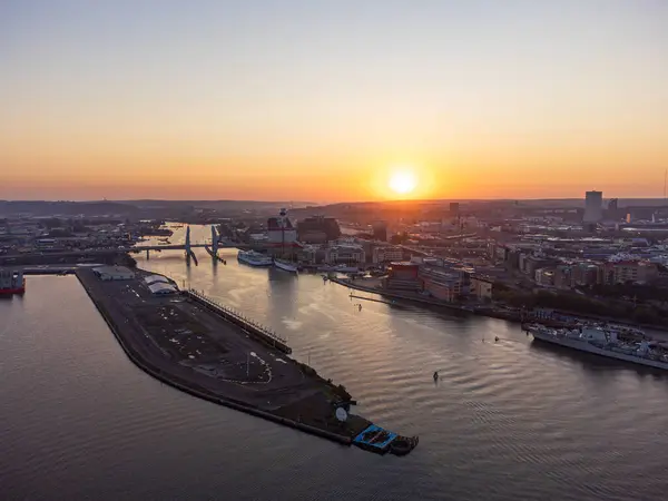 Göteborg, İsveç - 5 Eylül 2024: Gündoğumunda Göteborg ufuk çizgisi, hava manzarası, eski kasaba, nehir ve Hising köprüsü (Hisingbron), açık gökyüzü, turuncu ve sarı renkler.