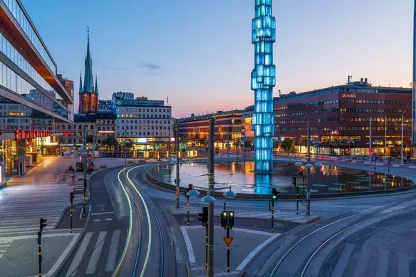 Stockholm, İsveç - 1 Ağustos 2024 Stockholm şehir merkezi, Sergel Meydanı gece. Uzun pozlama, araba ışık yolları, gün batımı ışığı, aydınlık binalar.