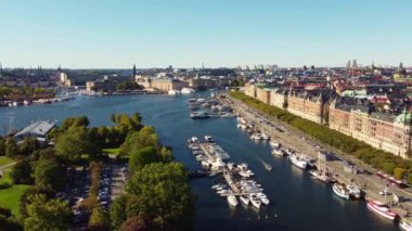 Strandvagen, Stockholm 'ün ünlü sokağı, sonbaharın başında, yukarıdan, 19. yüzyılın sonlarına doğru binalar ve yeşil ağaçlardan oluşan bir ara sokak. Rıhtımda tekneler. Yürüyen insanlar