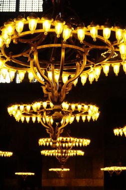 Ayasofya 'nın avizeleri görkemli bir parıltı yayarak, iç güzelliğinin ihtişamını arttırır.