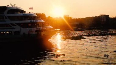 Nehir üzerinde güneşli arka planda hızla giden büyük bir yolcu gemisinin yan görüntüsü. Yaz tatili arka planı.