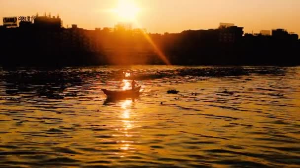 街のそばで日没したボートの動き ダッカ サダルガット駅と周辺エリアの空中観覧 川の風景美しい赤い空晴れた晴れた日川の街 — ストック動画