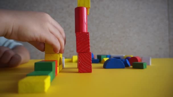 Ένα Παιδί Παίζει Πολύχρωμα Μπλοκ Μερικά Είναι Μπλε Κόκκινο Κίτρινο — Αρχείο Βίντεο