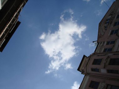 İki eski bina arasında gökyüzüne bakıyorum..