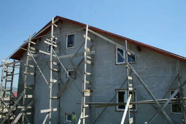 在建造过程中 有高脚手架支撑窗户的部分建成的房子 — 图库照片