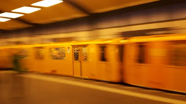 A blurry photo of a train in motion shows a streak of metal and smoke, with passengers visible through the windows..