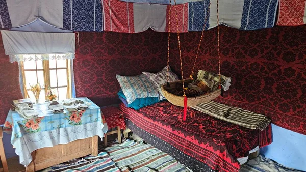 a retro room with a bed and a baby basket in the middle, old romanian house indoor from Arges county, romania