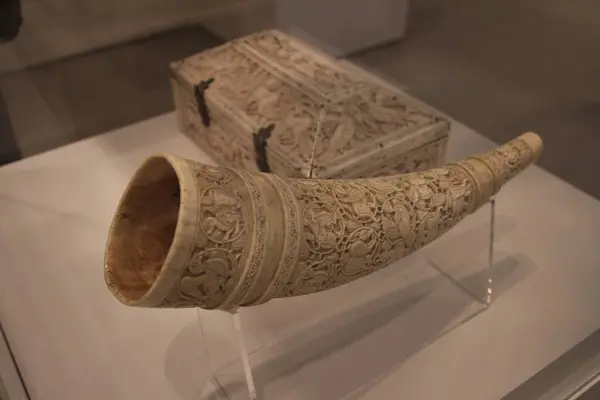 A Medieval Drinking Horn with intricate carvings on display at museum