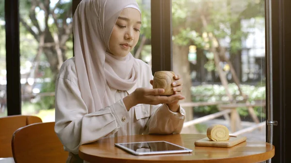 明るい晴れた日にコーヒーショップでリラックスした瞬間を楽しむ上向きのモバイルアジアのムスリム女性 — ストック写真