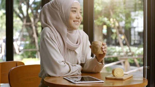 明るい晴れた日にコーヒーショップでリラックスした瞬間を楽しむ上向きのモバイルアジアのムスリム女性 — ストック写真