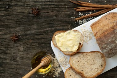 Yeni pişirilmiş geleneksel İtalyan Ciabatta ekmeklerinin ahşap bir masada servis edilmek üzere dilimlenip dilimlendiği yakın plan bir üst görüntüsü.