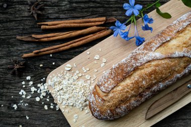 Yeni pişirilmiş geleneksel İtalyan Ciabatta ekmeklerinin ahşap bir masada servis edilmek üzere dilimlenip dilimlendiği yakın plan bir üst görüntüsü.
