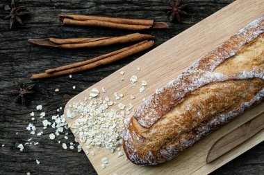 Yeni pişirilmiş geleneksel İtalyan Ciabatta ekmeklerinin ahşap bir masada servis edilmek üzere dilimlenip dilimlendiği yakın plan bir üst görüntüsü.