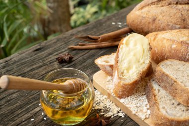 Yeni pişirilmiş geleneksel İtalyan Ciabatta ekmeklerinin ahşap bir masada servis edilmek üzere dilimlenip dilimlendiği yakın plan bir üst görüntüsü.