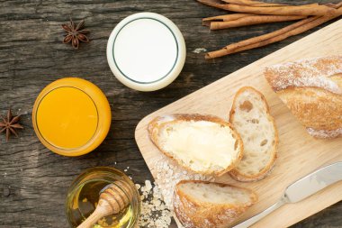 Yeni pişirilmiş geleneksel İtalyan Ciabatta ekmeklerinin ahşap bir masada servis edilmek üzere dilimlenip dilimlendiği yakın plan bir üst görüntüsü.