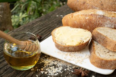 Yeni pişirilmiş geleneksel İtalyan Ciabatta ekmeklerinin ahşap bir masada servis edilmek üzere dilimlenip dilimlendiği yakın plan bir üst görüntüsü.