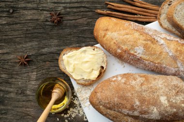 Yeni pişirilmiş geleneksel İtalyan Ciabatta ekmeklerinin ahşap bir masada servis edilmek üzere dilimlenip dilimlendiği yakın plan bir üst görüntüsü.