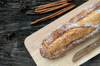 Yeni pişirilmiş geleneksel İtalyan Ciabatta ekmeklerinin ahşap bir masada servis edilmek üzere dilimlenip dilimlendiği yakın plan bir üst görüntüsü.