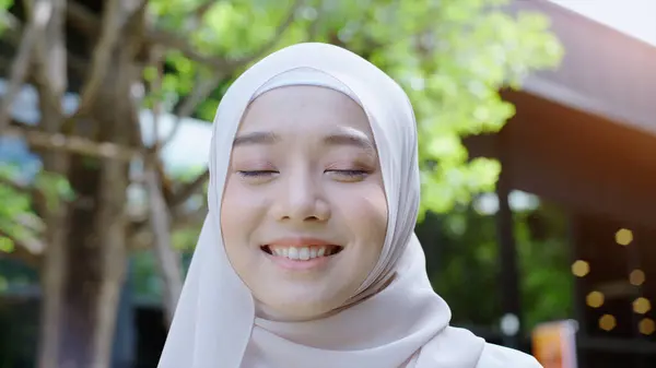 若いアジアのイスラム教徒の女性の肖像画を閉じる 伝統的なヒジャブを着て自信を持って見て 背景として白い壁でカメラで笑顔 — ストック写真