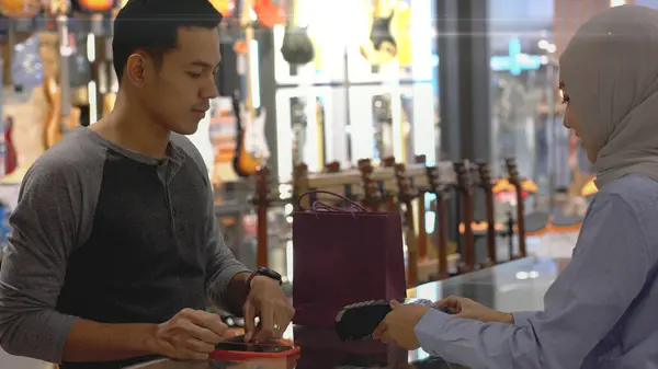 一名上流社会的亚洲穆斯林男子用手机 聪明的家伙在销售终端支付产品的费用 用Nfc识别码支付验证和认证费用 — 图库照片