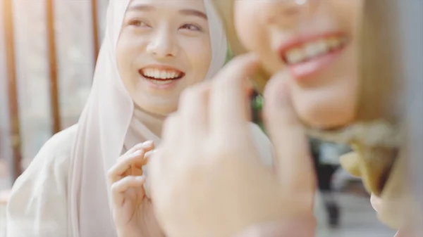 若い美しいアジアのムスリム女性は 明るい晴れた日にコーヒーショップでモバイルデビューと遊ぶリラックスした瞬間を楽しんでいます — ストック写真