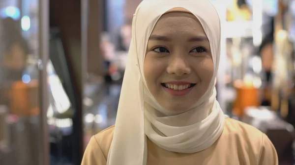 自信を持って笑顔でカメラを見ている伝統的なヒジャブの服を着た若いアジアのムスリム女性の肖像画を閉じる — ストック写真
